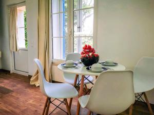 a white table with chairs and a vase of flowers on it at Garden's Nest - East Villa in Conceição