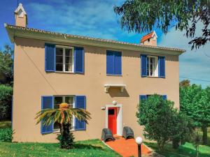 a house with blue shutters and a red door at Garden's Nest - East Villa in Conceição