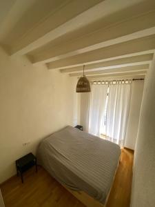 een slaapkamer met een bed en een groot raam bij Apartamento casco antiguo tarragona in Tarragona