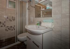 a white bathroom with a sink and a toilet at Apartman Domenika in Makarska +14 photos