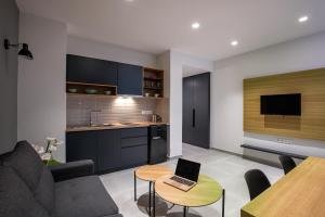 Traveleclectic Apartments في مدينة كورفو: غرفة معيشة مع أريكة وجهاز كمبيوتر محمول على طاولة