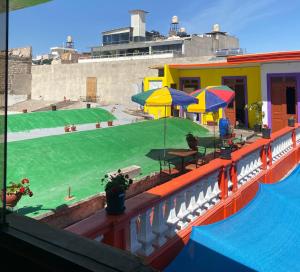 una piscina con mesas y sombrillas en un edificio en pusary hostel, en Arequipa