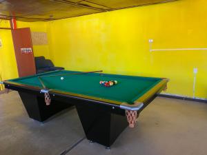 a pool table in a room with a yellow wall at pusary hostel in Arequipa