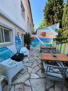 a patio with tables and chairs next to a building at Ljmonade Hostel in Cascais