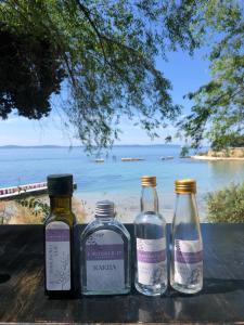 three bottles sitting on a table with a view of the ocean at Lavender cozy & lovely 17 in Split