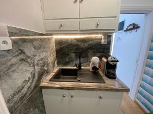 a kitchen counter with a sink and a microwave at Veranta Vosporos in Poros