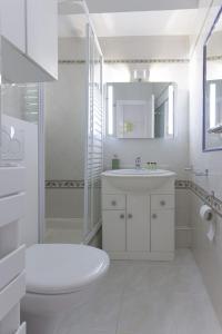 Baño blanco con aseo y lavamanos en Un Écrin au Suquet - Studio, clim, balcon, plage, Palais des Festivals en Cannes