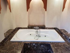 a bath tub with a faucet in a room at Villa Luxe in Marrakech