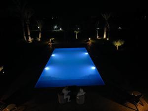 a blue bench in the middle of a yard at night at Villa Luxe in Marrakech