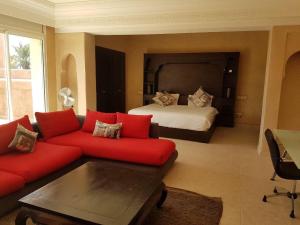 un soggiorno con divano rosso e letto di Villa Luxe a Marrakech