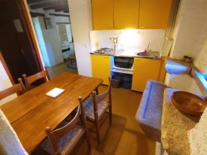 une cuisine avec une table en bois et des armoires jaunes dans l'établissement Bienvenue en Transition 46 - Camoussel, à Najac