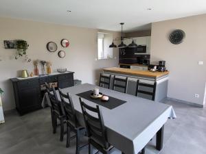 a kitchen with a table and chairs in a kitchen at Gîte La Motte in Vesly