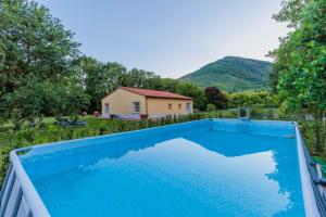 einen Pool in einem Hof mit einem Haus in der Unterkunft Villa Bassotta, a Charming Cottage in Lucca