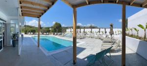 a pool at a resort with lounge chairs at FRESH HOTEL FALIRAKI in Faliraki