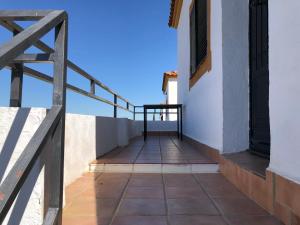 balcón de un edificio blanco con barandilla de madera en Apartamentos Atalayas Extremadura en Zafra