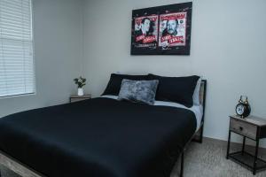 a bedroom with a black bed with a clock on the wall at Beautiful TownHome With Garage in Las Vegas in Las Vegas