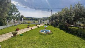 a garden with a fountain in the middle of the grass at Isidoros house in Néa Sílata