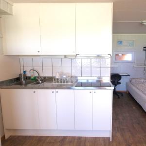 a kitchen with white cabinets and a sink at Bedder at Oslo Airport - serviced apartments in Jessheim