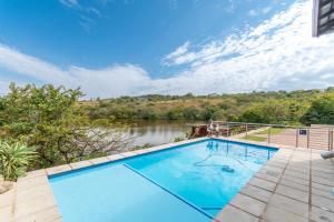 a swimming pool with a river in the background at 21 Wildfig- Live with Nature with Power Backup in White River