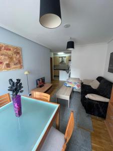- un salon avec une table et un canapé dans l'établissement Apartamento acogedor próximo a playas y aeropuerto, à La Corogne