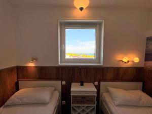 2 Betten in einem Zimmer mit Fenster in der Unterkunft Ferienpark Sierksdorf App 748 - Strandlage in Sierksdorf