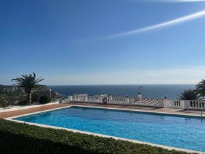 una piscina con vista sull'oceano sullo sfondo di Inga´s Apartment ad Alaior