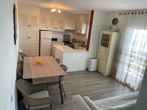 una cucina con tavolo e una cucina con frigorifero di Inga´s Apartment ad Alaior