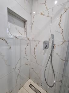 y baño con ducha y paredes de mármol. en Bellos House en Párga