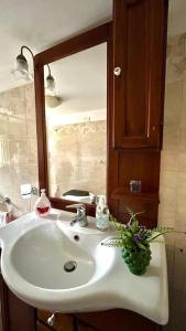 a bathroom with a white sink and a mirror at CASA VACANZE DON VARTULIDDU in Scicli