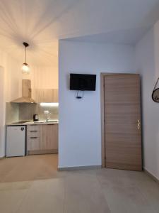 a kitchen with a door with a television on the wall at Bellos House in Parga