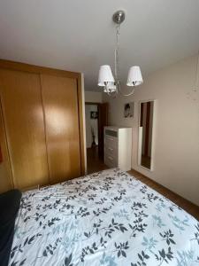 um quarto com uma cama com um cobertor azul e branco em Apartamento acogedor próximo a playas y aeropuerto em La Coruña
