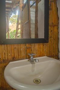 a sink in a bathroom with a mirror and a window at Ipqua Hostel in Palomino