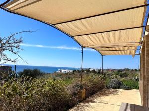 awning over a patio with a view of the ocean at Villa Mariapaola in Torre Vado
