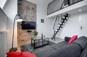 un soggiorno con divano e muro di mattoni di Apartament Romantyczny Zamkowa15 a Cracovia