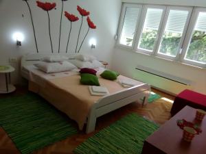 a bedroom with a bed with flowers on the wall at Apartment Calluna in Split