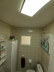 a bathroom with a toilet and a window at Casa Bart de vacaciones in Mazarrón