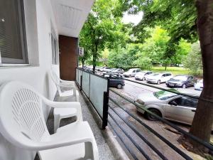 a balcony with white chairs and a car on a street at Апартамент за гости, ж.к. Зорница , бл.9 in Burgas City