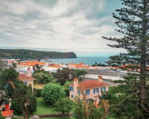 a view of a town with the ocean in the background at Garden's Nest - North Villa in Conceição