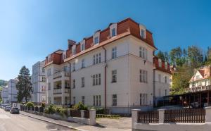 un gran edificio blanco con techo marrón en Apartmán Masaryk, en Český Krumlov