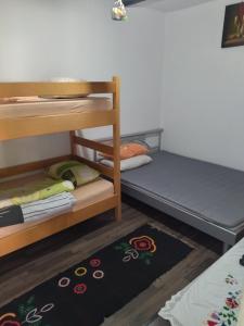 a room with two bunk beds and a rug at Mikin vajat i ribnjak Korenita, Loznica in Loznica