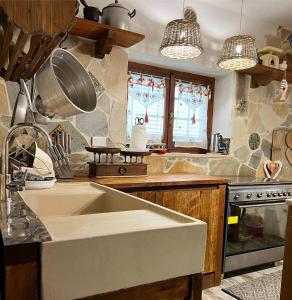 a kitchen with a sink and a stove and windows at B&B Casa de' Trinci in Foligno