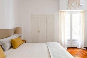 a white bedroom with a large bed and a window at A Friendly Room in the Heart of Recoleta -in Shared Apartment- in Buenos Aires