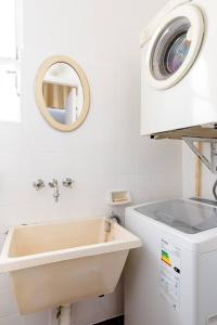 a bathroom with a sink and a washing machine at A Friendly Room in the Heart of Recoleta -in Shared Apartment- in Buenos Aires