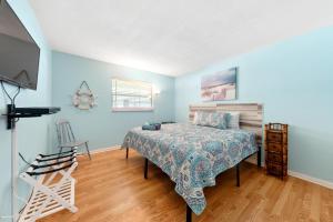 1 dormitorio con 1 cama y TV en Beach Villa A, en Clearwater Beach