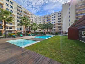 a large apartment building with a swimming pool at River Terrace & Pool View - Seixal in Seixal