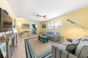 a living room with two couches and a tv at Beach Villa A in Clearwater Beach