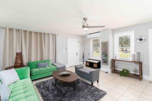 a living room with a green couch and a table at Private welcoming Unit Near Beaches #A in St Petersburg