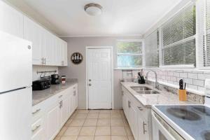 a kitchen with white cabinets and white appliances at Private welcoming Unit Near Beaches #A in St Petersburg