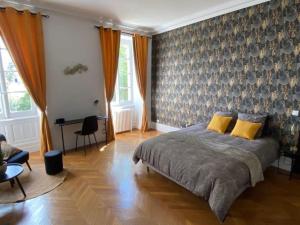 - une chambre avec un grand lit et des oreillers jaunes dans l'établissement Appartement - 2 chambres - Parking voiture, à Mazamet