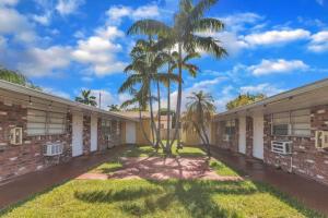 a row of buildings with palm trees in the courtyard at Blissful Studio in Hallandale Beach 8mins to beach in Hallandale Beach